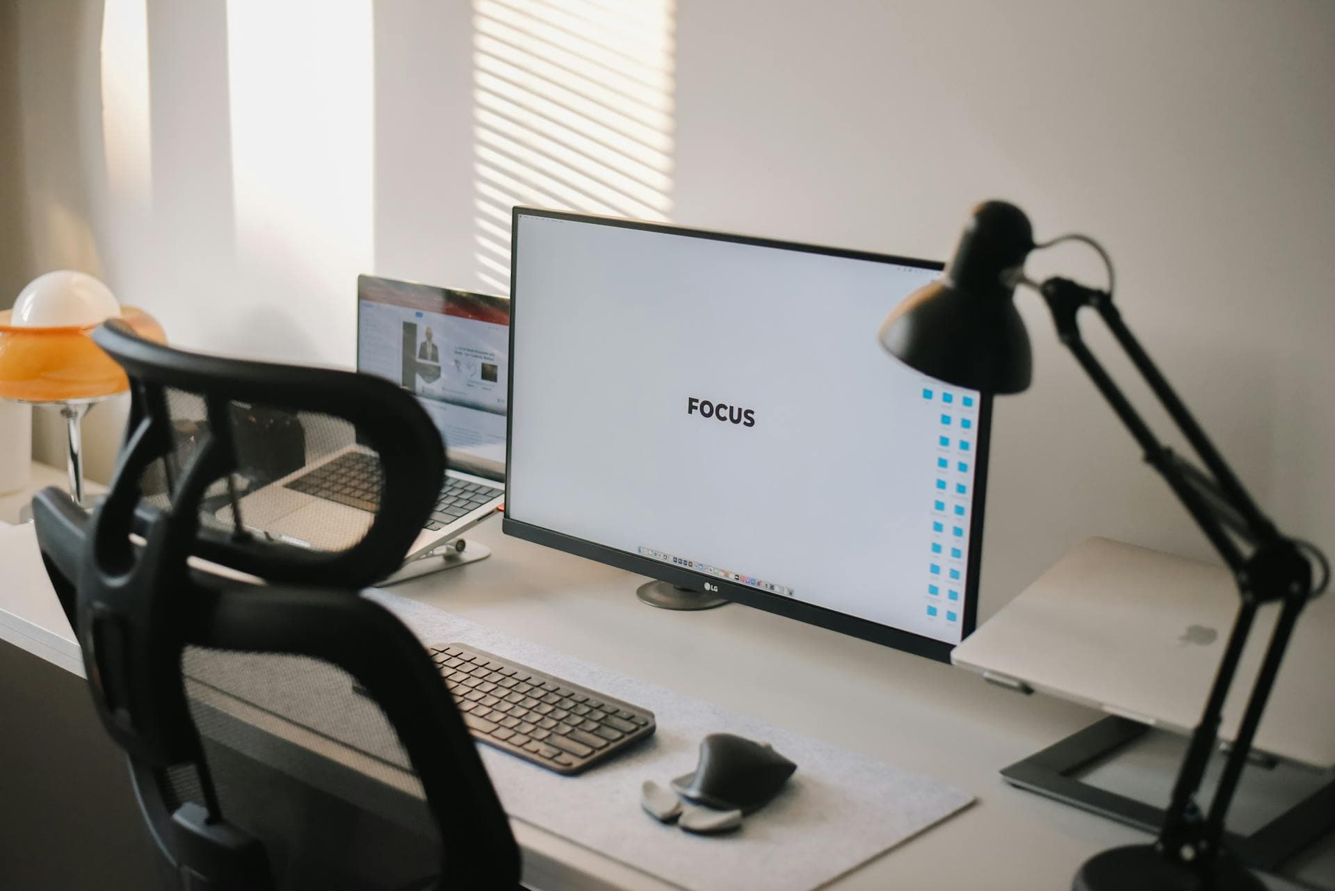 Escritorio de trabajo con monitor, laptop y teclado